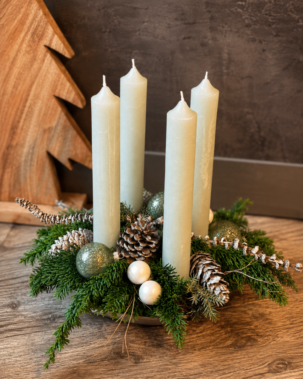 Adventsgesteck mit vier cremefarbenen Stabkerzen, Zapfen und Tannengrün