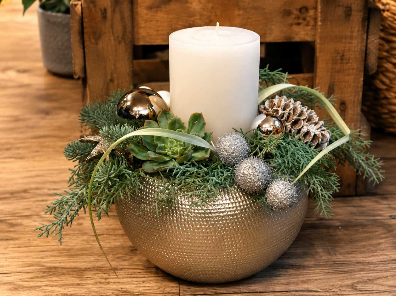 Winterliches Gesteck in goldener Schale mit weißer Kerze und Sukkulente
