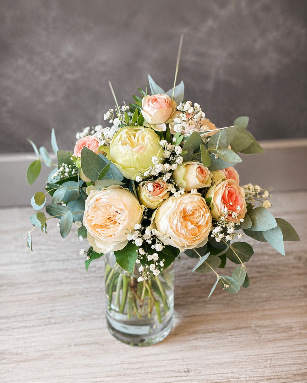 Zarter Strauß in Creme und Apricot mit Eukalyptus im Glas