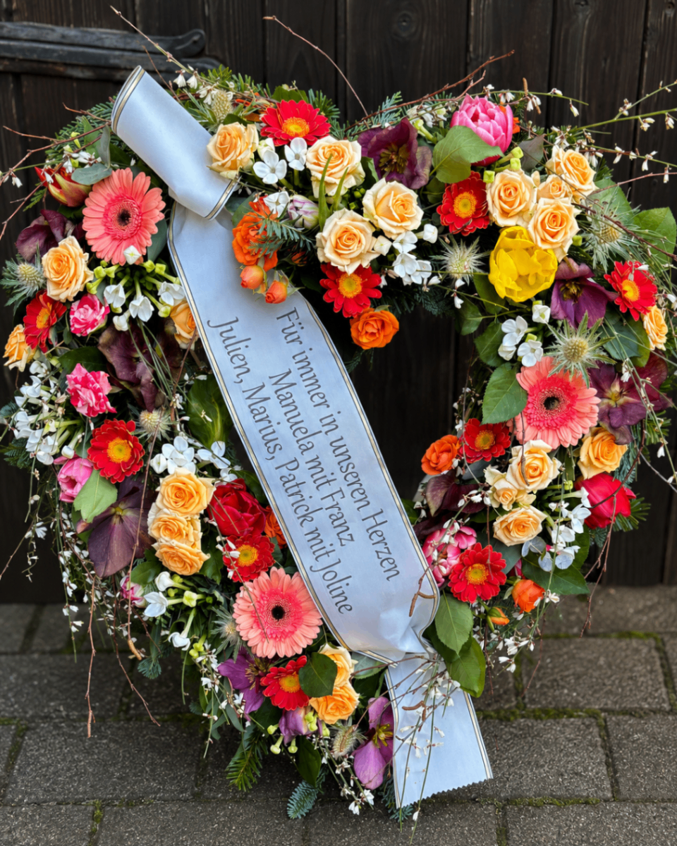 Bunter Trauerkranz mit hellblauer Schleife